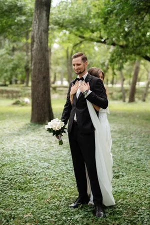 Happy newlywed couple in park with bouquet