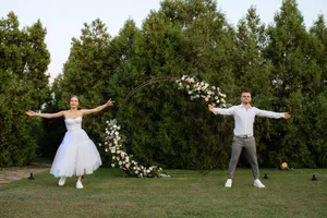 Happy groom playing badminton with bride in the park.