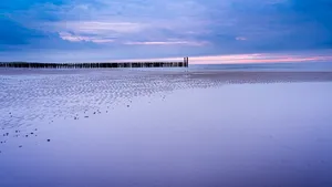 Tranquil coast under sun with ocean waves