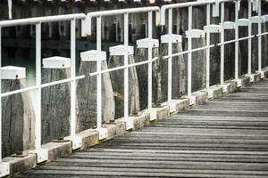 Cityscape with water view and picket fence barrier.