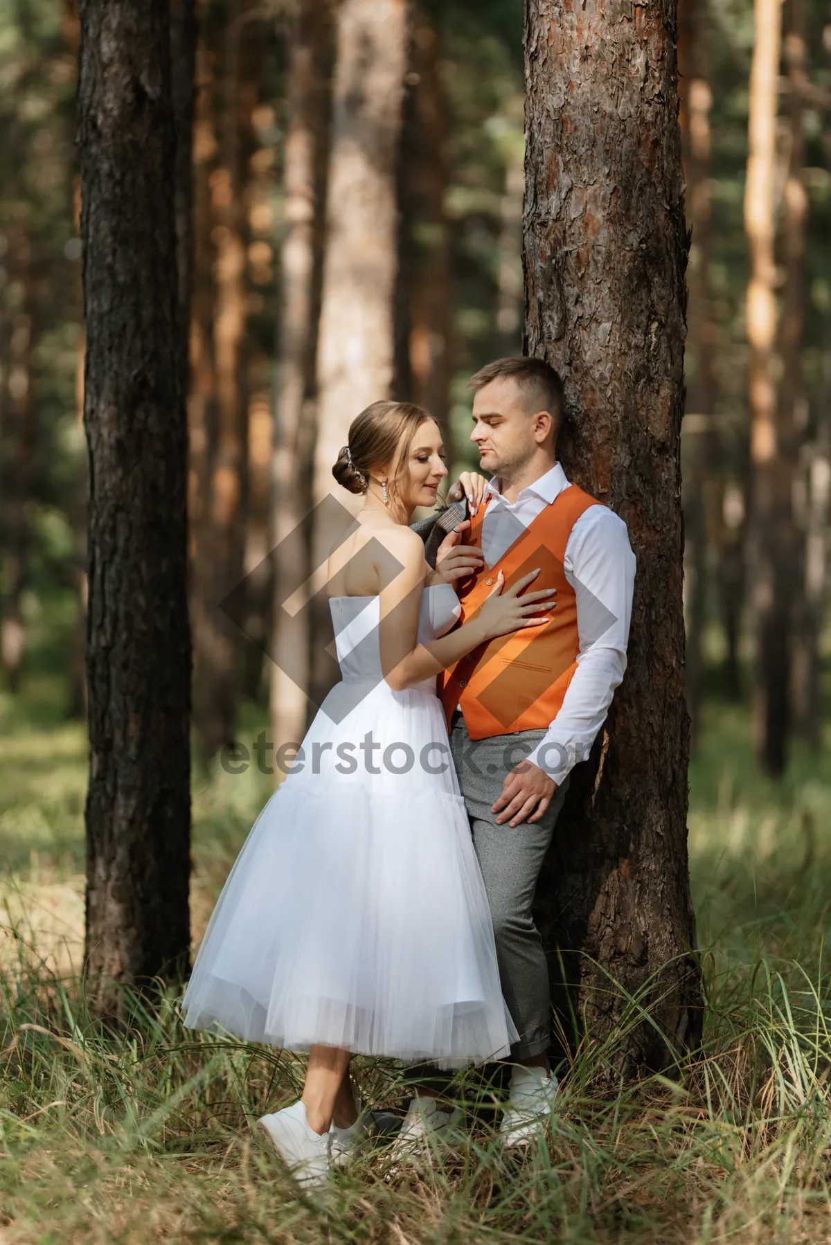 Picture of Happy couple celebrating wedding outdoors in summer with flowers.