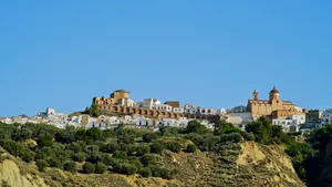 Medieval castle overlooking city skyline with ancient ruins.