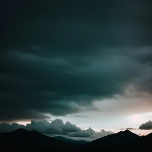 Serenity at Sunset: Majestic Mountain Range Under Glowing Clouds