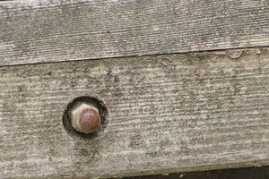 Rusty Metal Fastener on Aged Wooden Surface