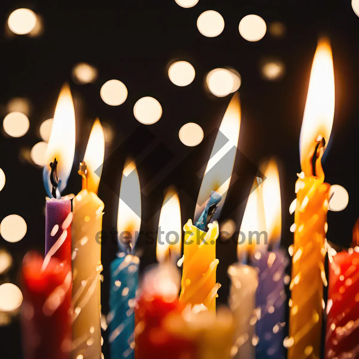 Picture of Burning orange candle with dark background glow.