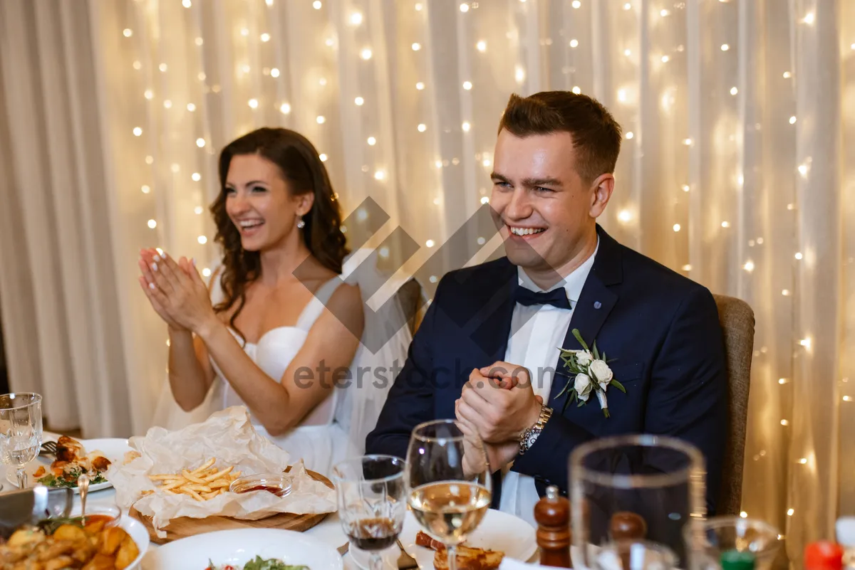 Picture of Happy adult couple celebrating wedding at restaurant table.