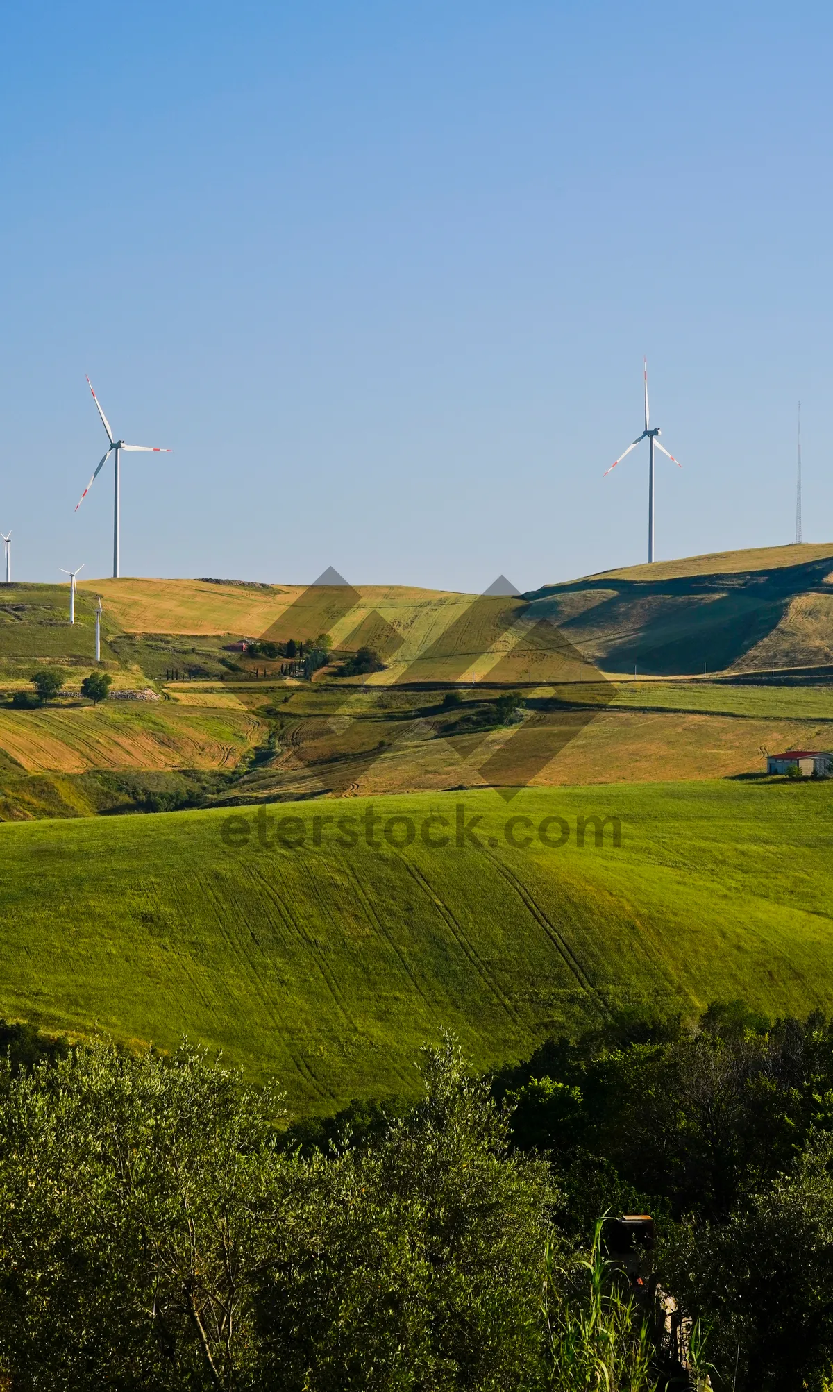 Picture of Rural mountain landscape with cloudy sky and wind turbine.