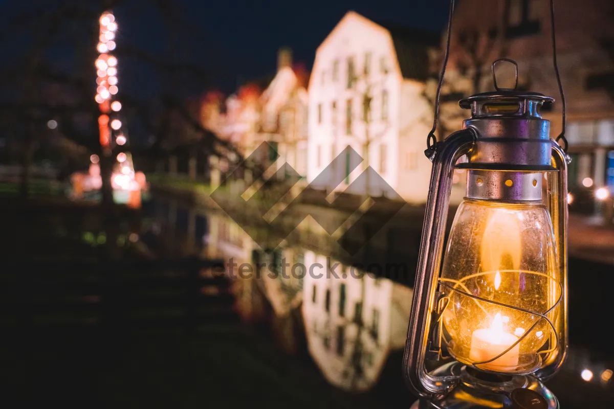 Picture of City lights reflecting on bridge over river at night.