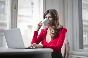 Confident businesswoman smiling at laptop in office