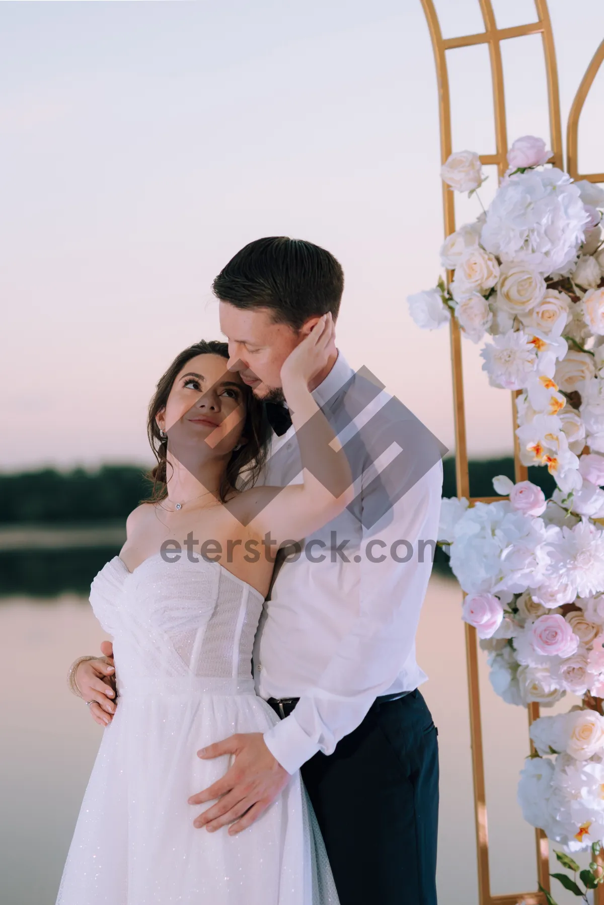 Picture of Smiling couple celebration outdoors wedding day flower bouquet.