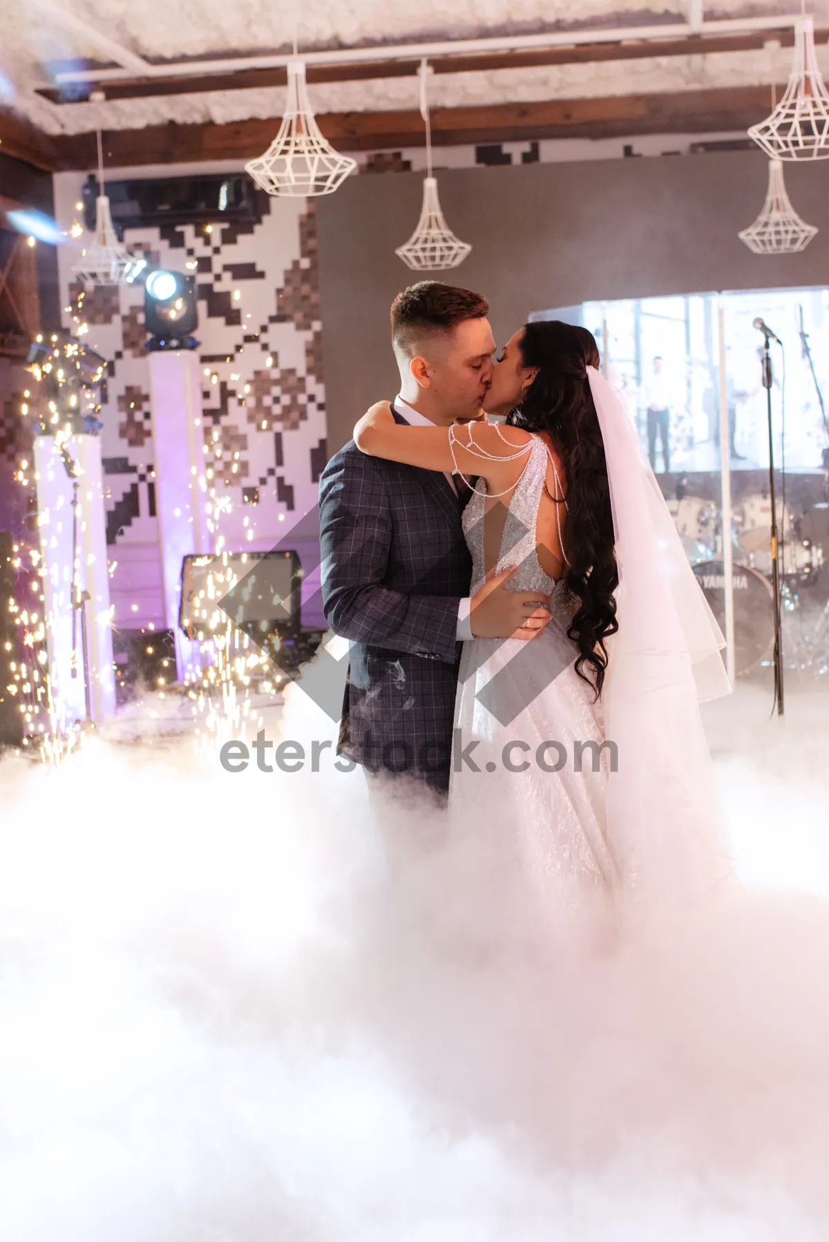 Picture of Happy newlyweds in wedding attire holding bouquet of flowers