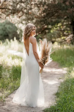 Blond bride in elegant wedding gown smiling happily