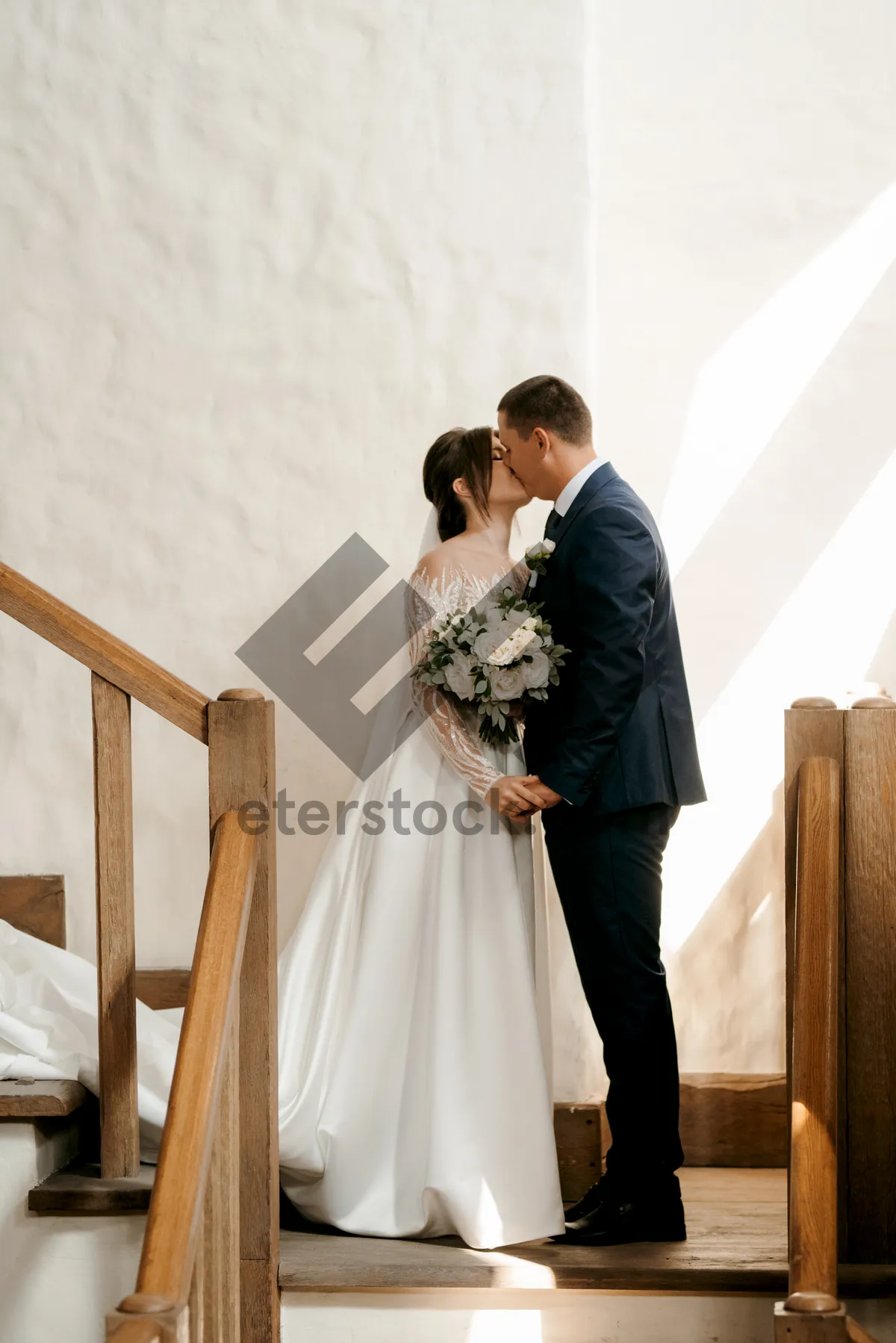 Picture of Happy newlyweds with bouquet on wedding day.