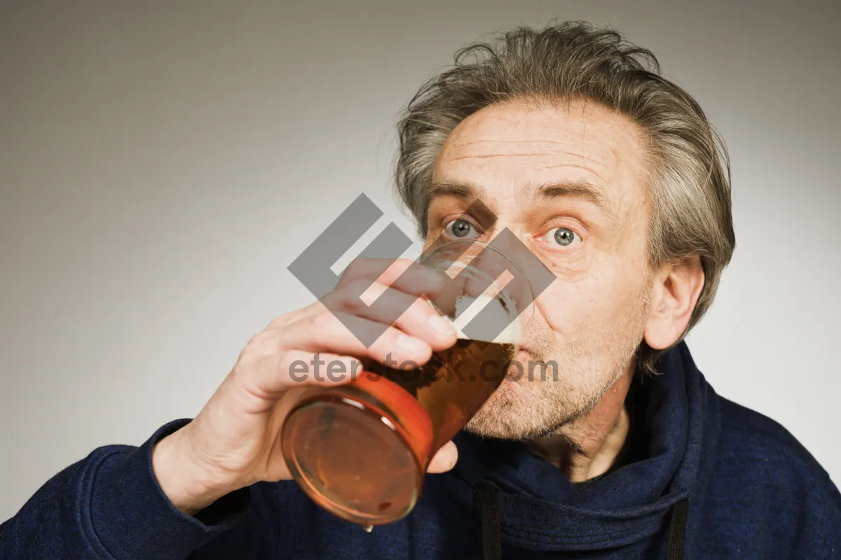 Picture of Man holding measuring cup of alcoholic drink.