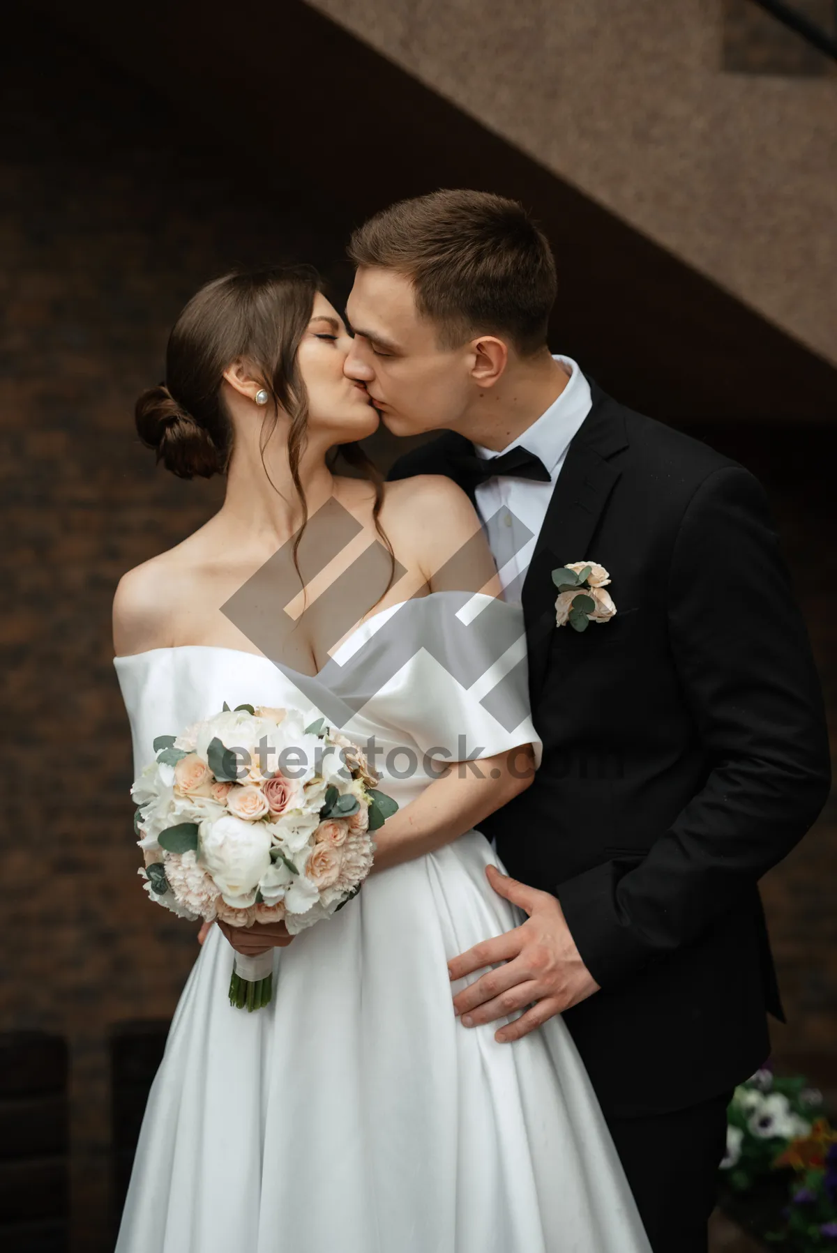 Picture of Celebrating couple in wedding attire with bouquet.