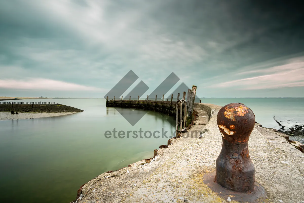 Picture of Scenic waterfront view with pier and clouds overhead