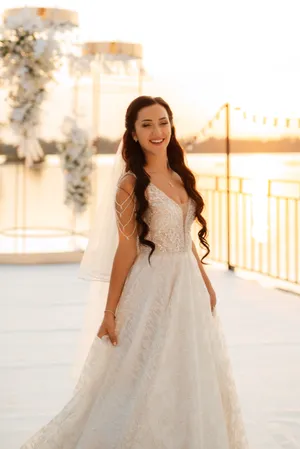 Elegant brunette bride in princess dress smiling happily.