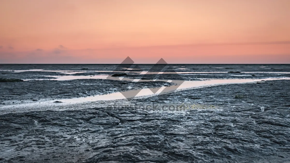 Picture of Tropical sunset over tranquil beach shoreline landscape.