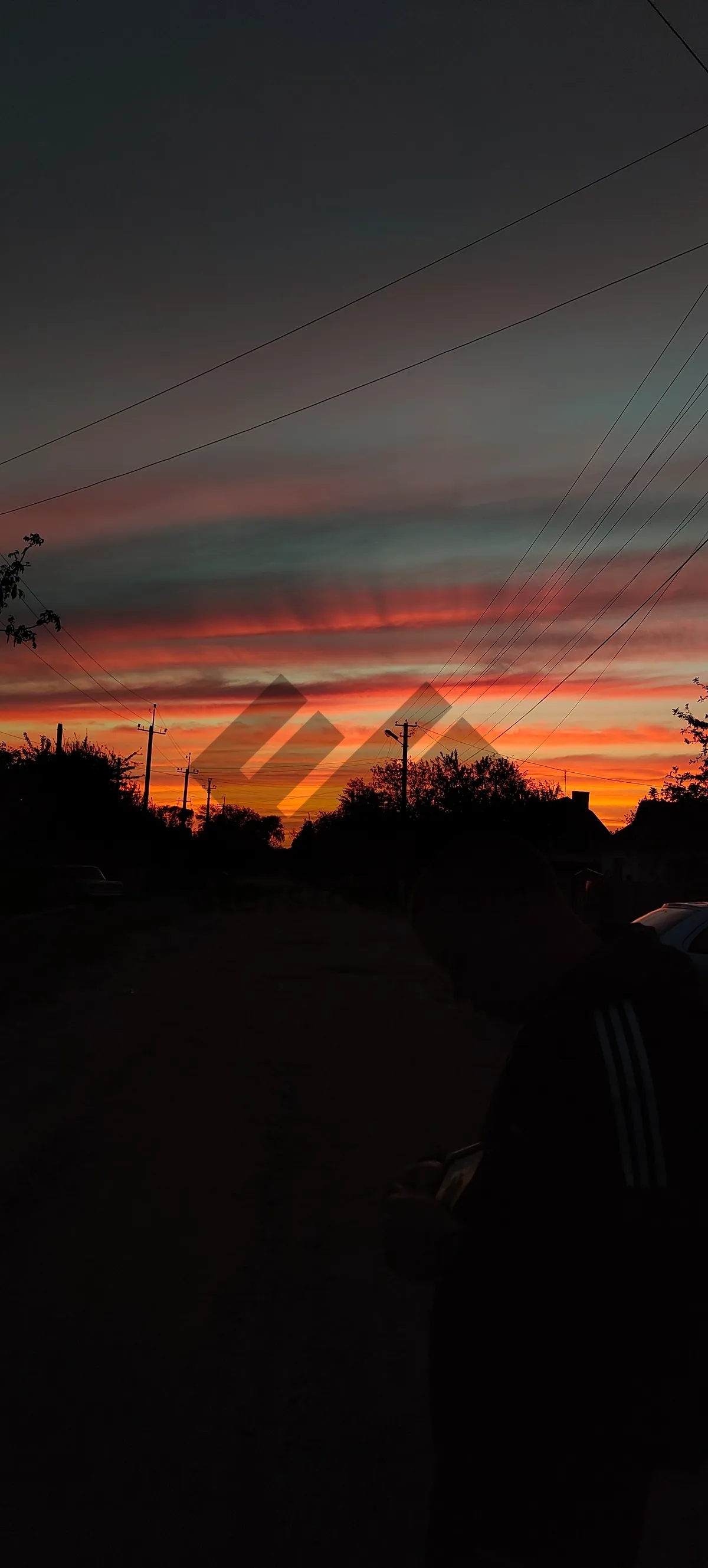 Picture of Orange sunset sky with silhouette cloud and cable wire.