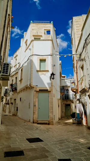 Historic stone building with balcony in urban cityscape.