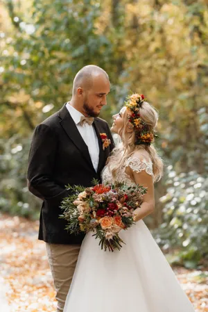 Happy couple celebrating their romantic wedding outdoors with flowers.