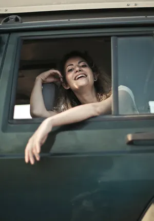 Attractive woman happy sitting in bathtub with car reflection