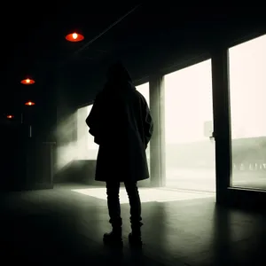 Urban Silhouette in Black Trench Coat Walking in Rainy City