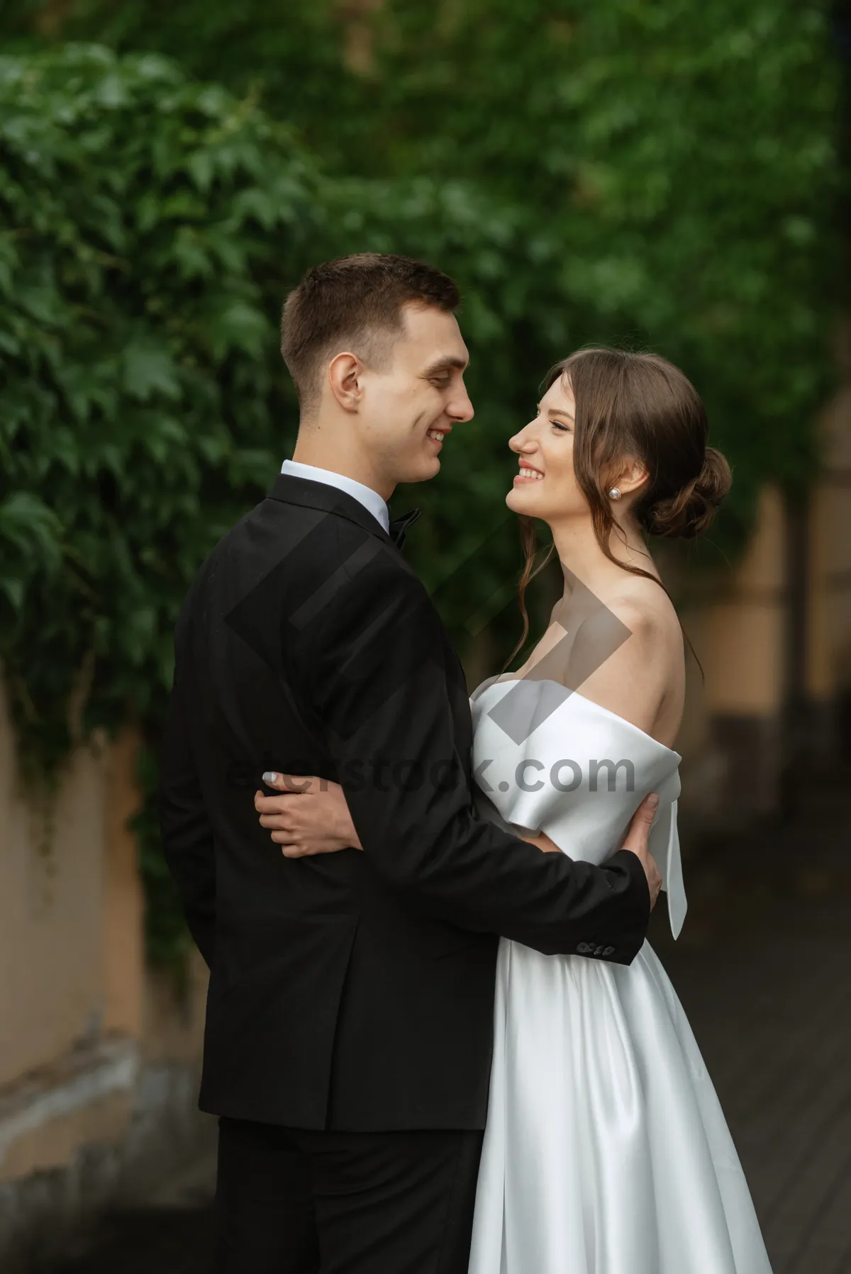 Picture of Happy couple in park on wedding day with flowers