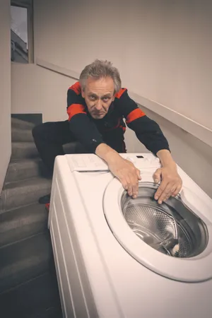 Man doing laundry at home with white washer appliance