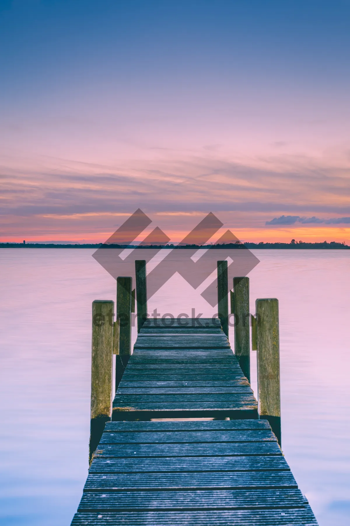 Picture of Wooden jetty and sunshine through clouds. Wooden pier at a lakeside.