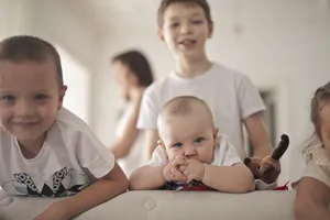 Happy Family Smiling Together in Bedroom