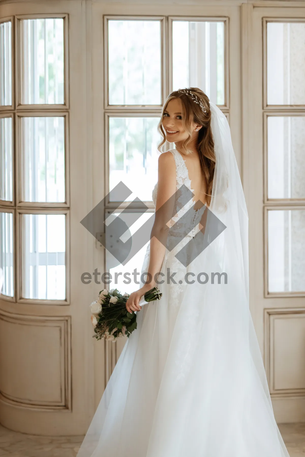 Picture of Brunette bride in elegant wedding gown smiling happily.