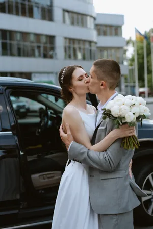 Happy couple celebrating wedding day with flowers outdoors
