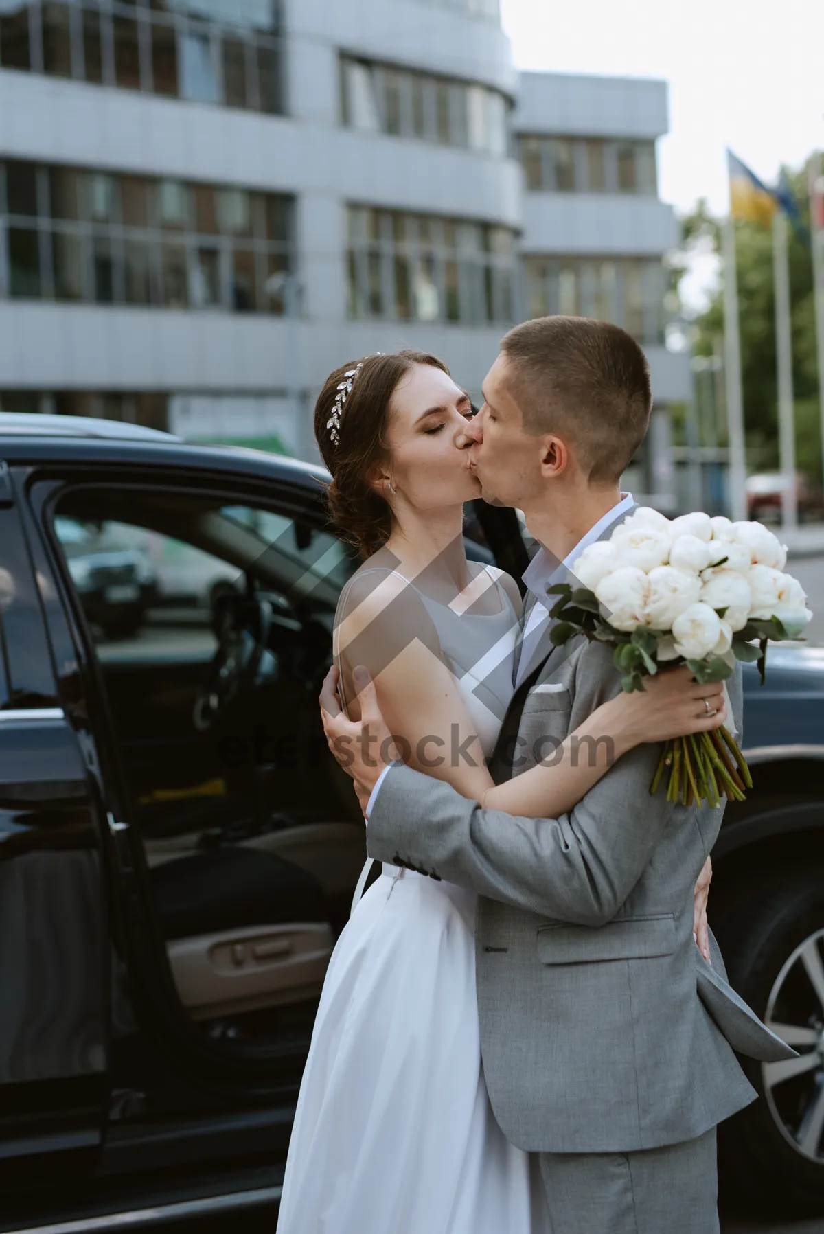 Picture of Happy couple celebrating wedding day with flowers outdoors