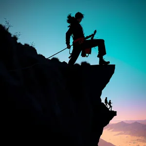 Adventurous male jumping rope against stunning sunset silhouette