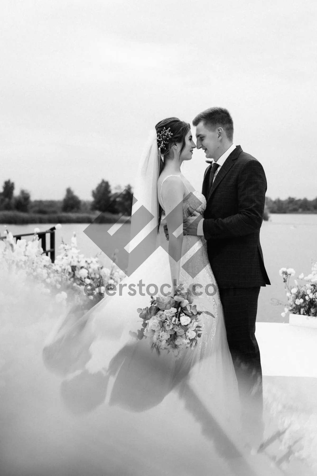 Picture of Happy newlywed couple celebrating outdoors with flowers