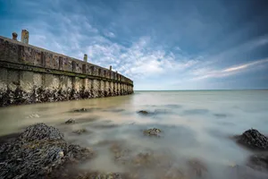 Tropical beach paradise with pier and clear skies.