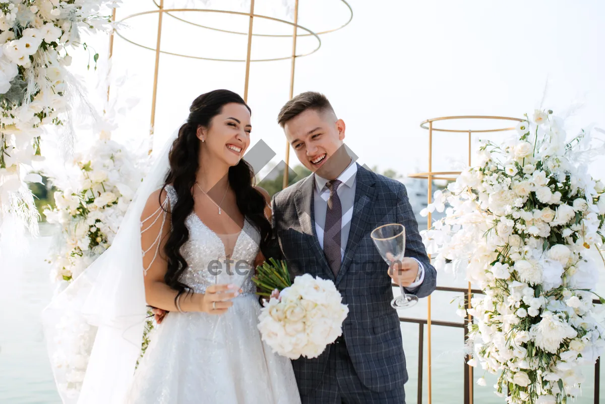 Picture of Happy newlywed couple holding bouquet at wedding ceremony