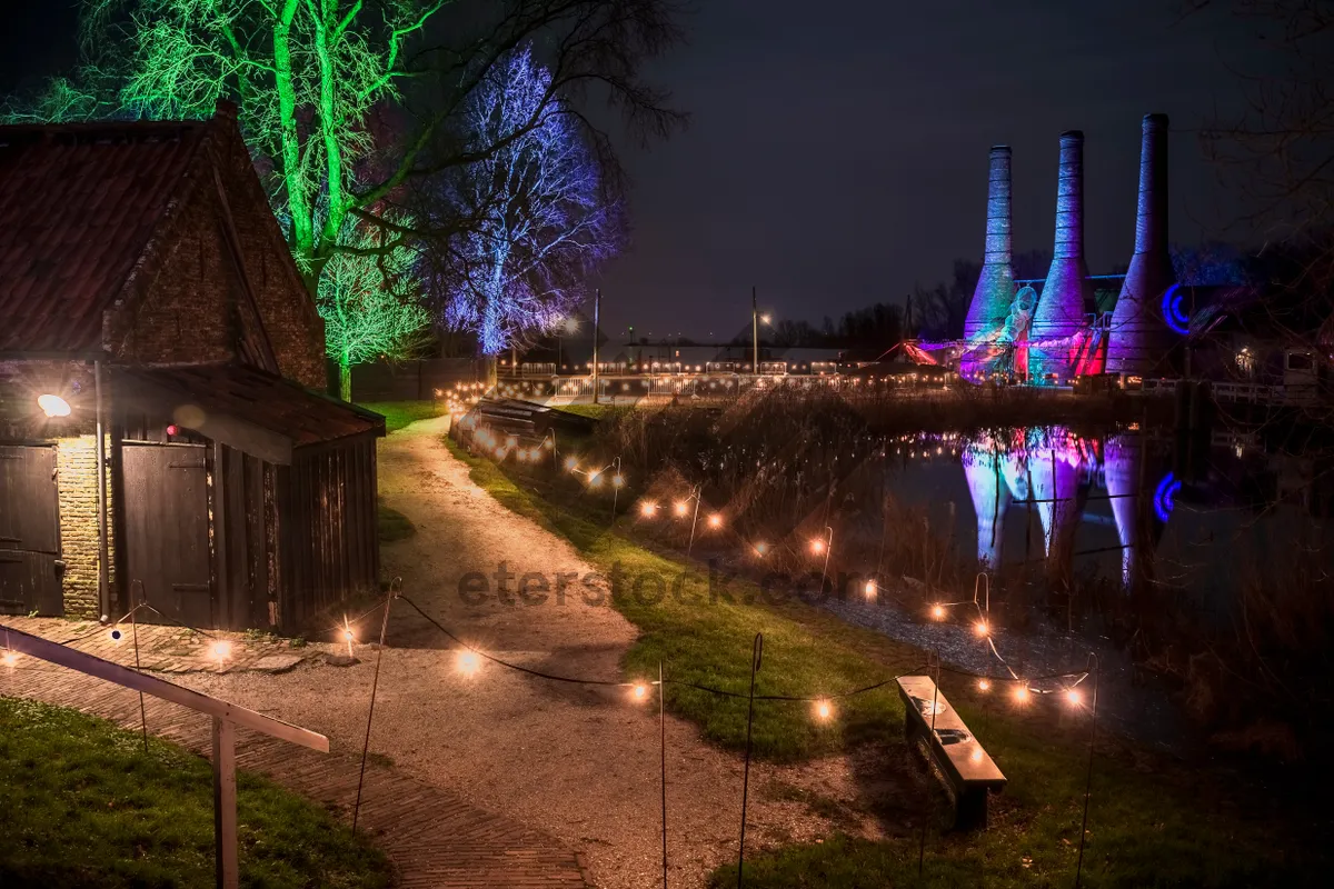 Picture of City skyline with suspension bridge over river at dusk