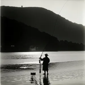 Silhouette of Fisherman Enjoying Beach Sunset with Fishing Gear