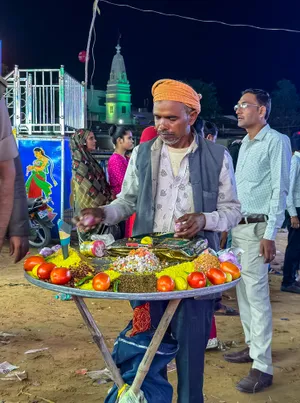 Happy fruit seller with handcart at outdoor market.