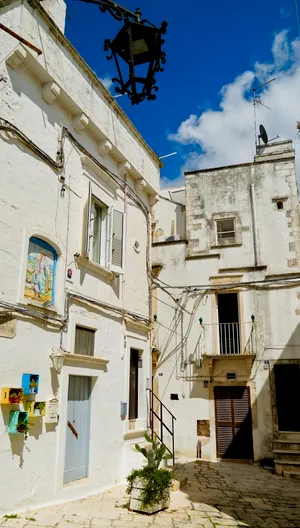 Historic stone monastery with balcony overlooking old city street.