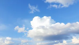 Bright summer sky with fluffy white clouds.