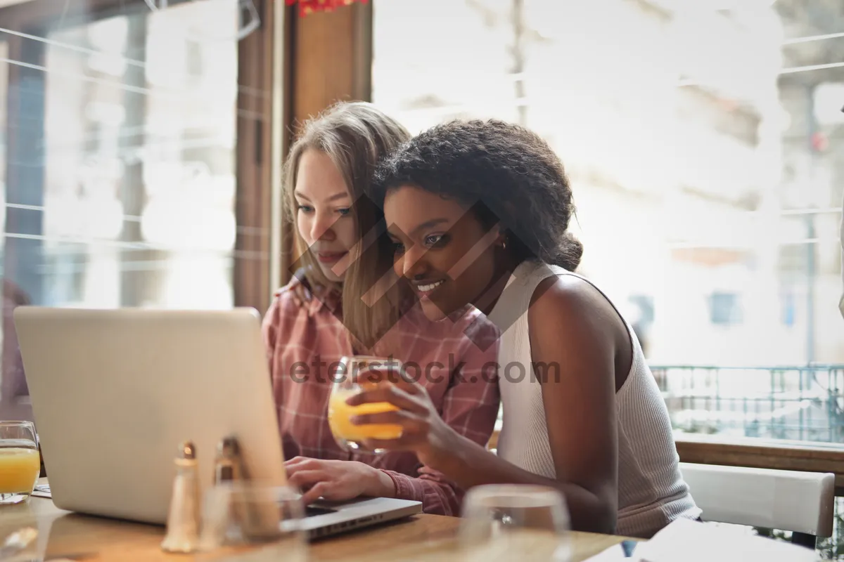 Picture of Happy couple dining at restaurant with laptop