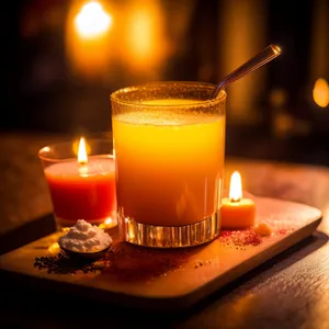 Healthy Orange Fruit Juice Drink with Ice and Candle
