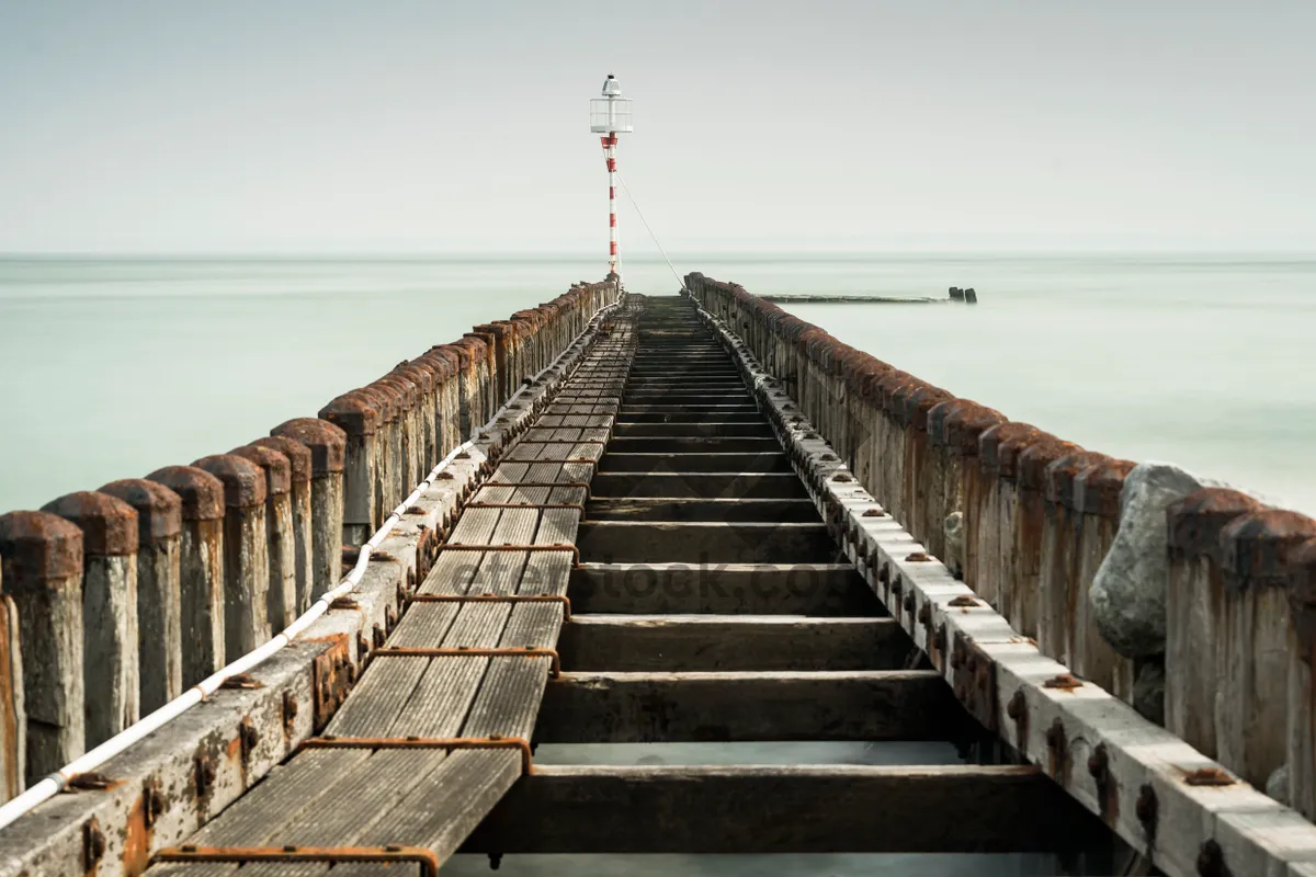 Picture of Wooden pier overlooking ocean with scenic clouds