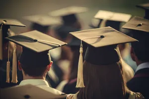 Adult in graduation gown and cap holding umbrella.