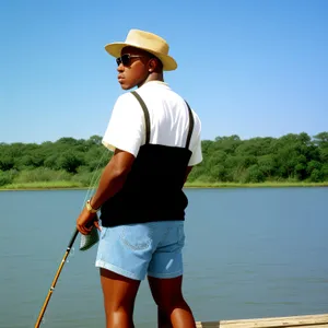 Joyful Fisherman Paddling with Fishing Gear in Summer