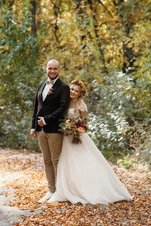 Happy groom smiling with bride on wedding day outdoors.