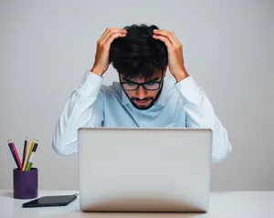 Happy businessman working on laptop at home office.